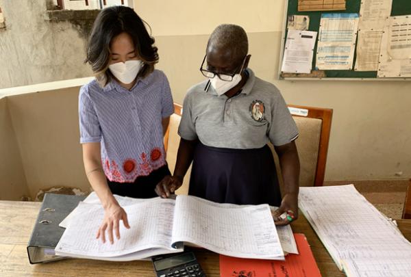 HaEun Lee and a colleague review TB records in Uganda