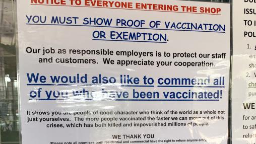 Sign on shop front in Kenya noting vaccination proof requirement to enter